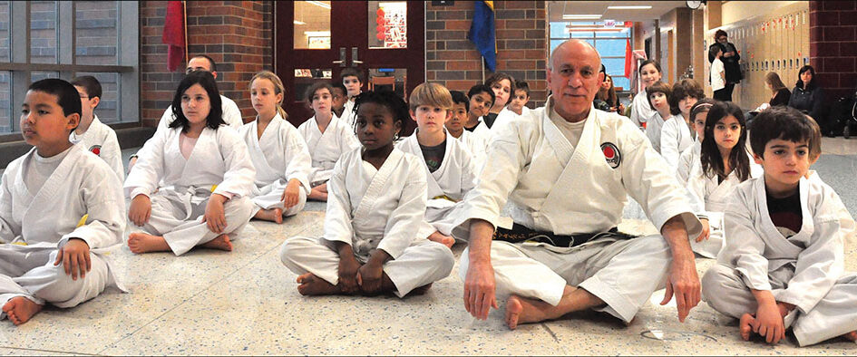 A group of kids sitting in front of an adult.