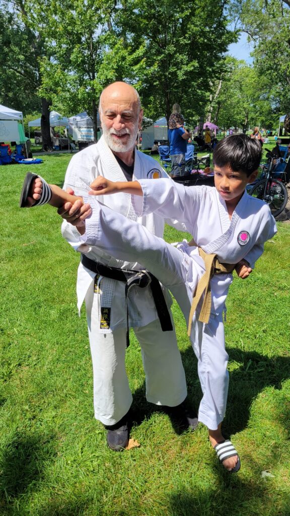 Instructor and Student (kid) training outside in grass.